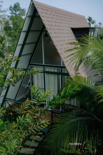 a house with glass windows and a roof at Royal Woods in Meppādi