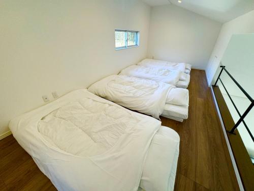 two beds sitting in a room with at BBQ可 ワンちゃんok ロフト付き平屋を貸切で楽しむ特別な空間 ハチん家 in Hokuto