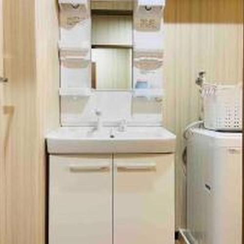 La salle de bains est pourvue d'un lavabo blanc et d'un réfrigérateur. dans l'établissement Alzate Uemachi 301 アルザーテ上町 301, à Osaka
