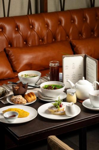 a table with plates of food on a couch at Mandarin Oriental, Guangzhou in Guangzhou