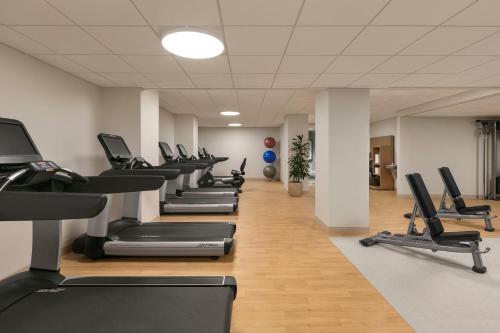 a gym with rows of treadmills and machines at Sheraton Raleigh Hotel in Raleigh