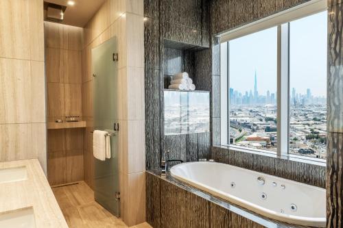 a bathroom with a bath tub and a window at Sheraton Mall of the Emirates Hotel, Dubai in Dubai