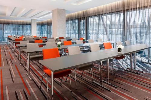 a large room with tables and chairs and windows at Sheraton Zürich Hotel in Zürich