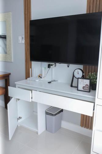 a desk with a large tv on top of it at Condo18k Beside Mactan Newtown in Lapu Lapu City