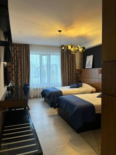 a hotel room with three beds and a table at Empire City in Karagandy