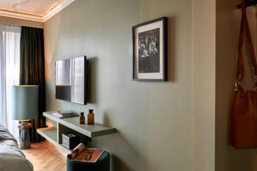 a room with a bed and a tv on a wall at Gekko House Frankfurt, a Tribute Portfolio Hotel in Frankfurt/Main