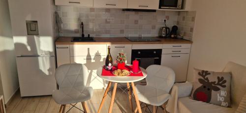 a kitchen with a small table with chairs and a counter at Három Testvér Apartman in Siófok