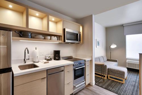 a small kitchen with a sink and a microwave at TownePlace Suites Salt Lake City Murray in Murray