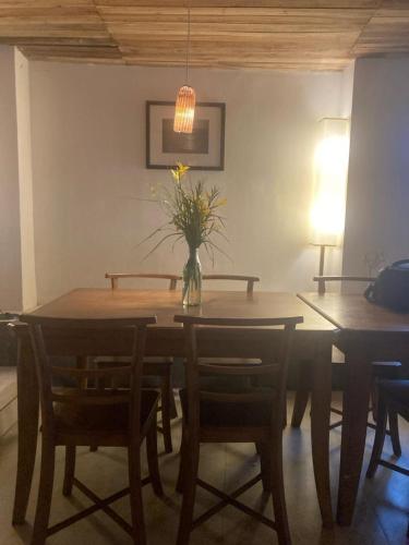 a dining room table with a vase of flowers on it at Acacia Inn in Horton Plains