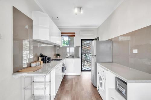 a large white kitchen with white cabinets and appliances at Charming Modern Retreat with Scenic View - Burnside in Burnside