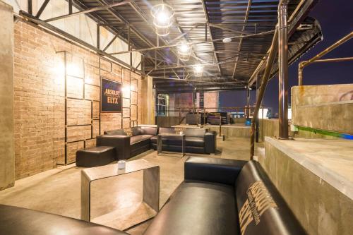 a bar with couches and tables in a room at Protea Hotel by Marriott Gaborone Masa Square in Gaborone