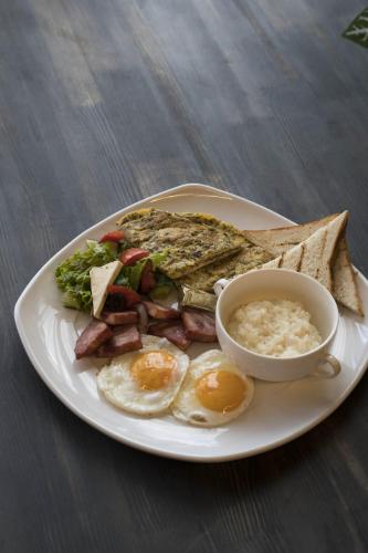 a plate of breakfast food with eggs sausage and rice at Empire City in Karagandy