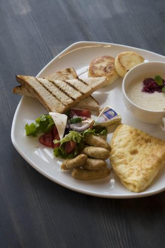 a white plate of food with a sandwich and toast at Empire City in Karagandy