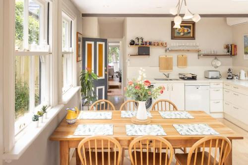 a kitchen with a wooden dining table and chairs at Charm & History 3bdr Cottage in Waverton, close to harbour views in Sydney