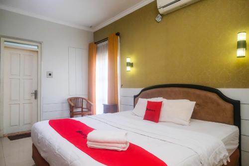 a bedroom with a large bed with red and white pillows at RedDoorz Plus near Adisucipto Airport 2 in Yogyakarta