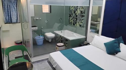 a bedroom with a bed and a bathroom with a sink at Hotel Sai Nidhi Residency in Thane