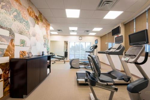 a gym with treadmills and ellipticals in a room at SpringHill Suites Midland in Midland