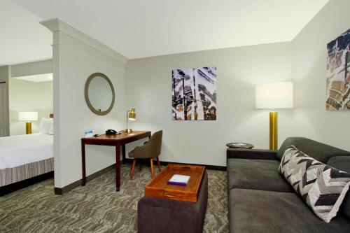 a hotel room with a couch and a bed and a desk at SpringHill Suites Phoenix Glendale Sports & Entertainment District in Glendale