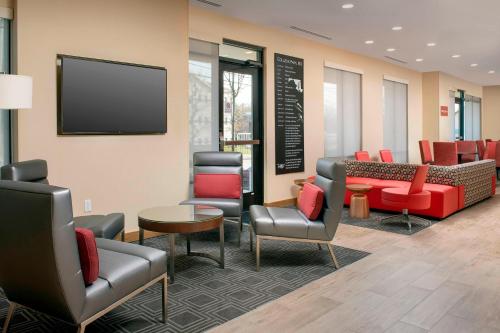 a waiting room with furniture and a flat screen tv at TownePlace Suites by Marriott College Park in College Park