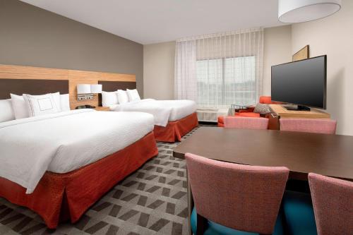 a hotel room with two beds and a flat screen tv at TownePlace Suites by Marriott College Park in College Park