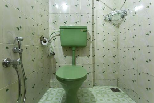 a bathroom with a green toilet and a shower at Sea Hut Homestay in Cochin