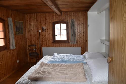 ein Schlafzimmer mit einem Bett in einem Zimmer mit Holzwänden in der Unterkunft Cricerhaus in Visp