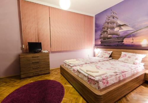 ein Schlafzimmer mit einem Bett und einem Schiffsbild in der Unterkunft Sea Garden Plaza Apartment in Burgas City