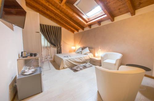 a bedroom with a bed and a chair in a room at Agriturismo Ca' La Pergola in Verona