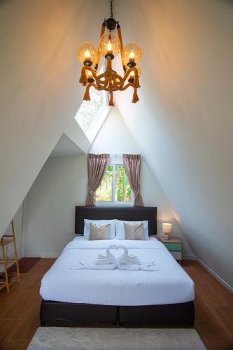 a bedroom with a large bed and a chandelier at Aob Khao Resort and Camping in Ban Pa Lau