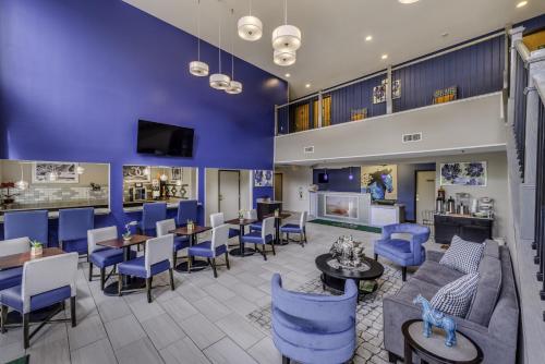 a lobby with blue chairs and tables at Guesthouse Inn & Suites Lexington in Lexington