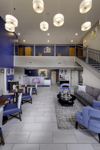 a lobby with couches and tables and a staircase at Guesthouse Inn & Suites Lexington in Lexington