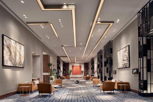 a lobby with a waiting area with chairs and tables at JW Marriott Hotel Monterrey Valle in Monterrey