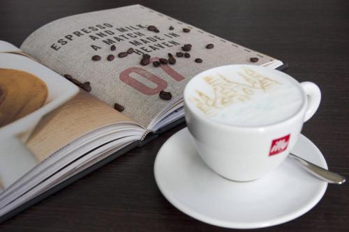 a cup of coffee sitting next to a book at Le Meridien Bangkok in Bangkok
