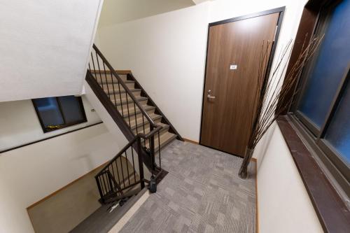 a stairway with a wooden door and a stair case at NAMBA STAY 302 新今宮 Shiimamiya in Osaka