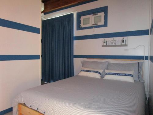 1 dormitorio con 1 cama con rayas azules y blancas en Ittiturismo Il Vecchio e il Mare, en Grottammare