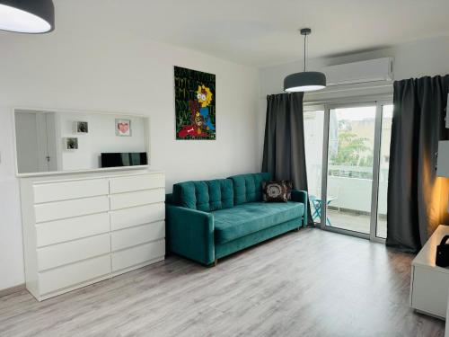 a living room with a blue couch and a window at White 1-bdr apartment Agyos Tychonas in Limassol