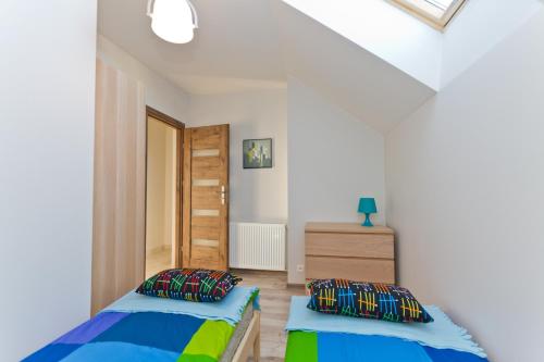 2 camas en un dormitorio con paredes blancas en RESORT Riva & Avir, en Jastrzębia Góra