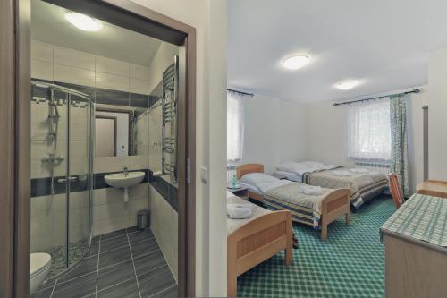 a hotel room with two beds and a bathroom at Pensjonat Limba in Duszniki Zdrój