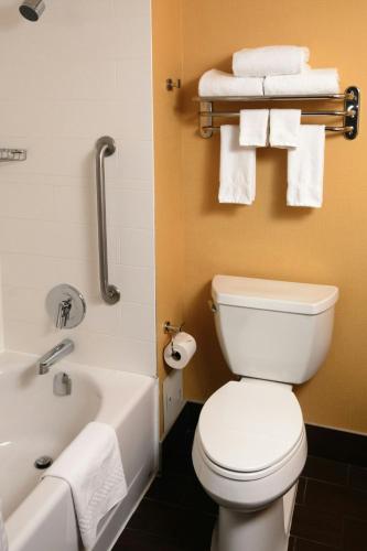 a bathroom with a toilet and a tub and towels at TownePlace Suites by Marriott Toronto Northeast/Markham in Markham
