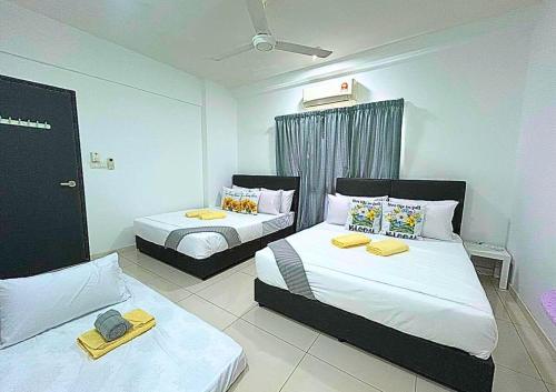 a bedroom with two beds with towels on them at Cozy Urban Retreat in Emira, Mall Next Door #EM1 in Shah Alam