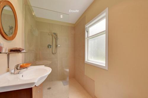 a bathroom with a sink and a shower at The Grand Old Lady of Staples in Motueka