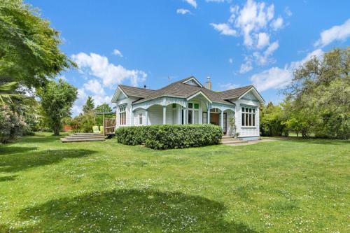 a house with a large yard in front of it at The Grand Old Lady of Staples in Motueka