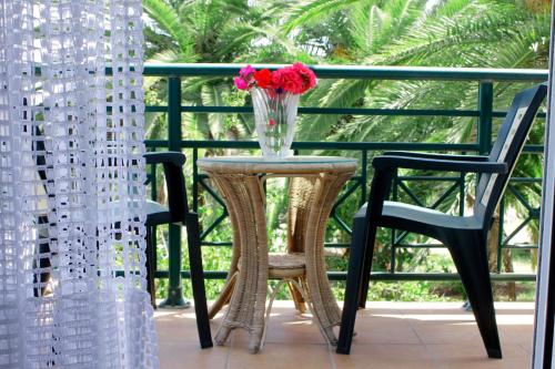 a vase of flowers sitting on a table on a balcony at Apartments Katoji in Chrani