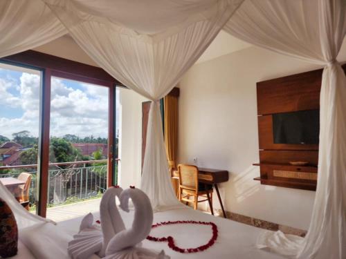 a bedroom with a bed with two swans on it at Sabana Bliss in Ubud