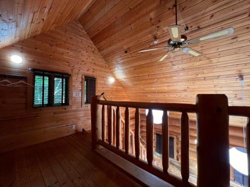 a log cabin with a ceiling fan and a staircase at Prime勝沼 森の中のプライベートログハウス 緑に包まれてBBQを楽しむ癒しの空間 in Koshu