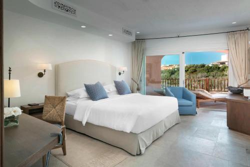 a bedroom with a large bed and a balcony at Cervo Hotel,Costa Smeralda Resort in Porto Cervo