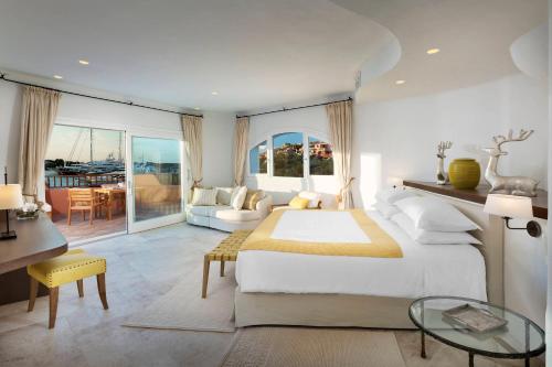 a bedroom with a large bed and a living room at Cervo Hotel,Costa Smeralda Resort in Porto Cervo