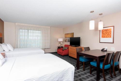 a hotel room with two beds and a desk at TownePlace Suites Fort Wayne North in Fort Wayne