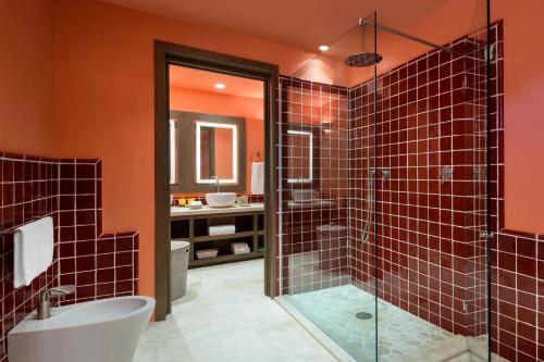 a bathroom with orange walls and a shower and a sink at Cervo Hotel,Costa Smeralda Resort in Porto Cervo