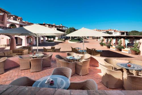 an outdoor patio with tables and chairs and umbrellas at Cervo Hotel,Costa Smeralda Resort in Porto Cervo